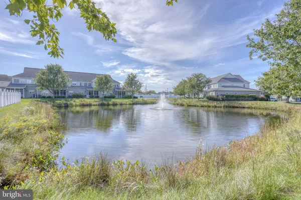 an aerial view of residential houses with outdoor space and lake view