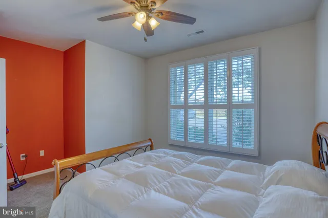 a bedroom with a bed and a tv on a dresser