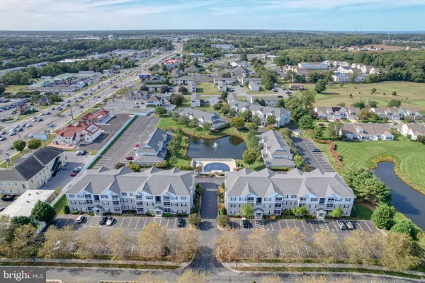 an aerial view of residential houses with outdoor space and parking