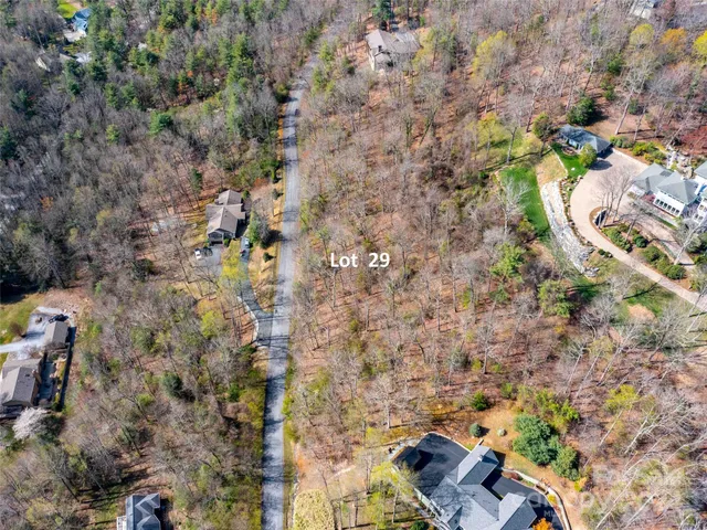 a aerial view of a house with a yard and large trees