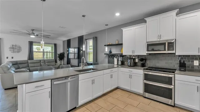 a kitchen with kitchen island granite countertop a sink and white stainless steel appliances