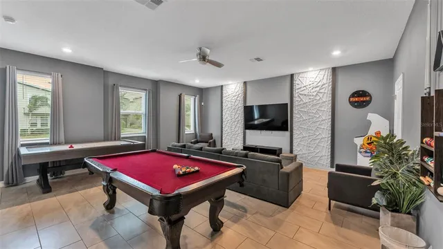 a room with pool table flat screen tv and windows