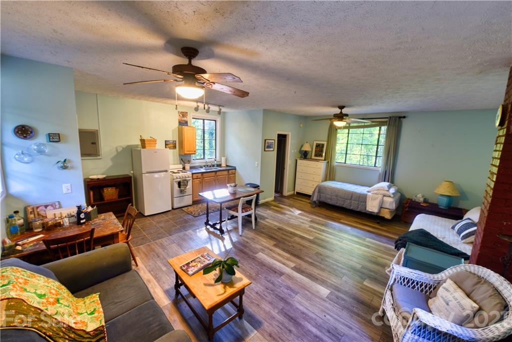 528 Wilderness Road Tryon, NC 28782 - Photo 25 of 29 a living room with furniture a fireplace and a chandelier