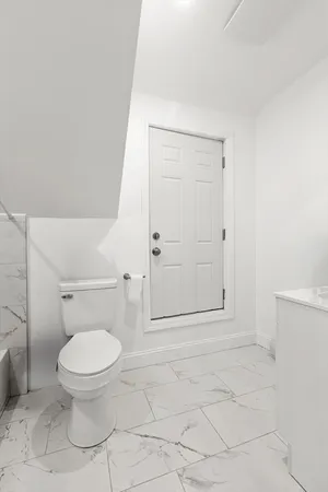 a bathroom with a toilet and a shower