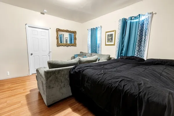 a bedroom with a bed and wooden floor
