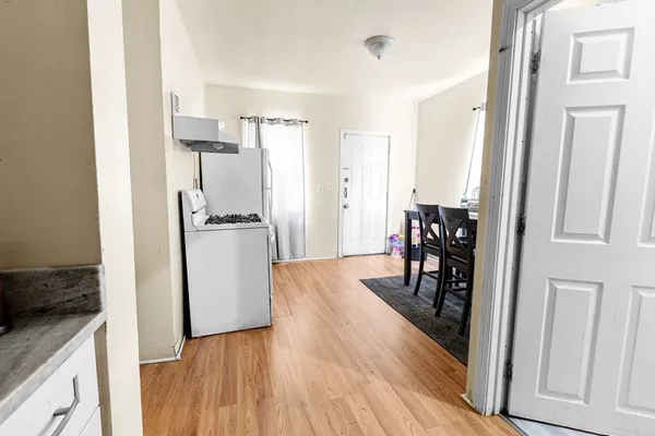 a kitchen with a refrigerator and wooden floor