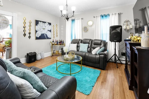 a living room with furniture a flat screen tv and kitchen view