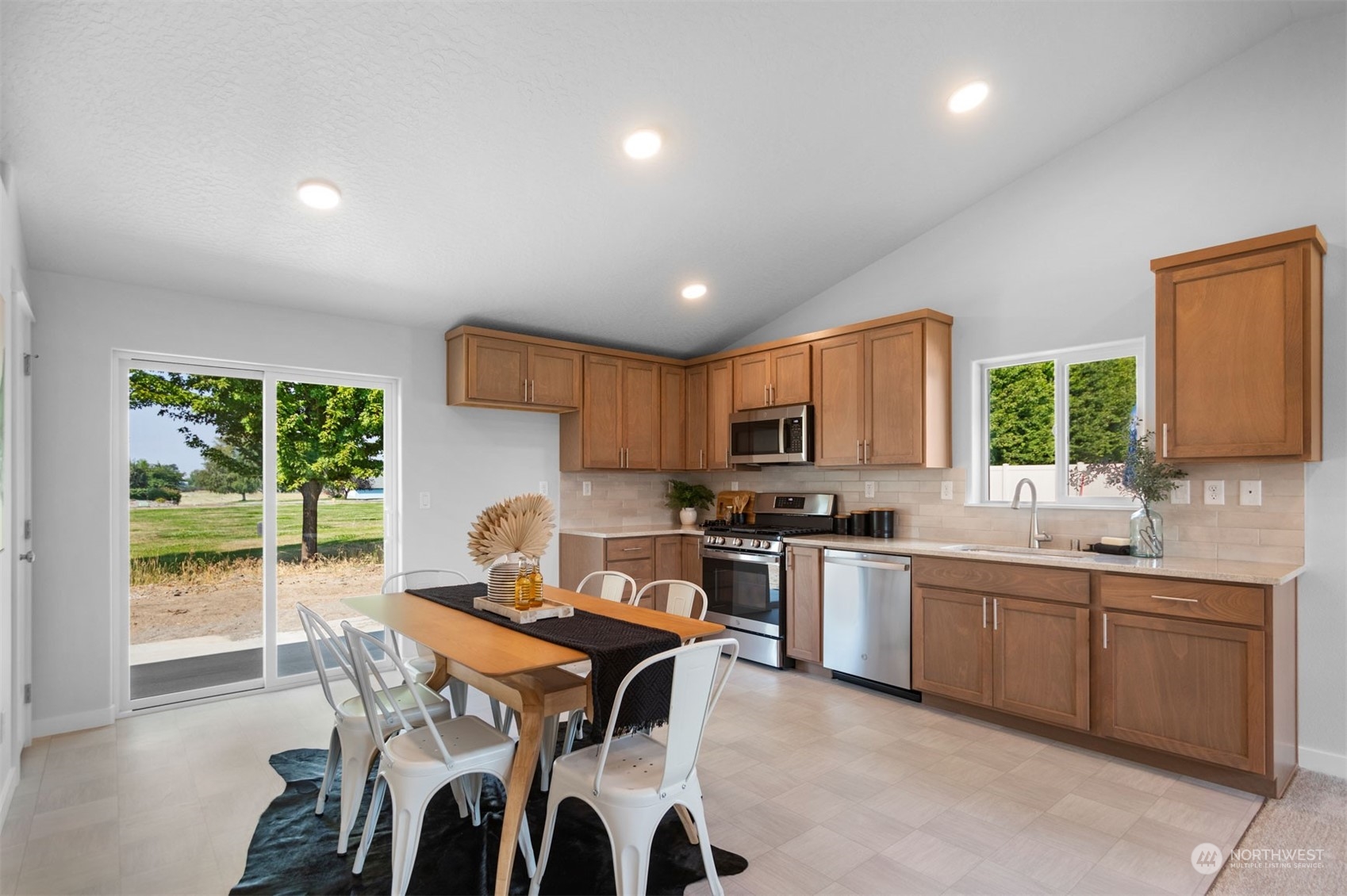 1906 Hickory Road Moses Lake, WA 98837 - Photo 6 of 16 a open kitchen with stainless steel appliances granite countertop a stove top oven a sink dishwasher a dining table and chairs with wooden floor