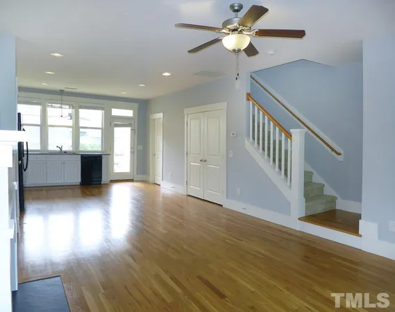 a view of an empty room with window and wooden floor