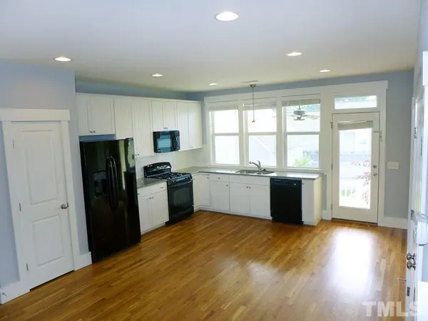 a kitchen with a refrigerator and a stove top oven