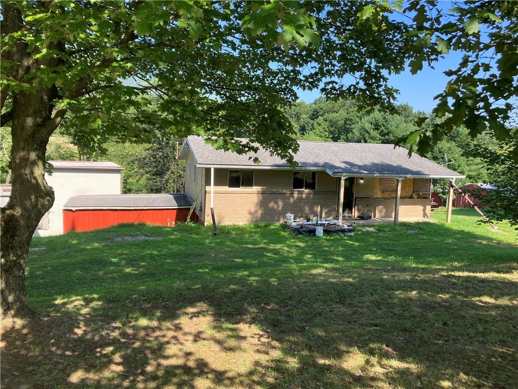a view of a house with a yard potted plants and large tree
