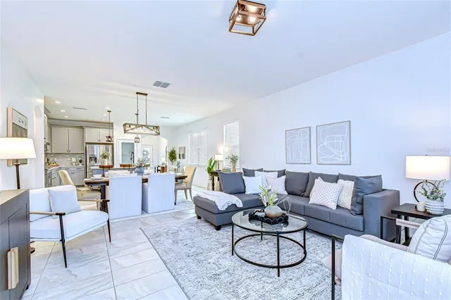 a living room with furniture and a dining table with wooden floor