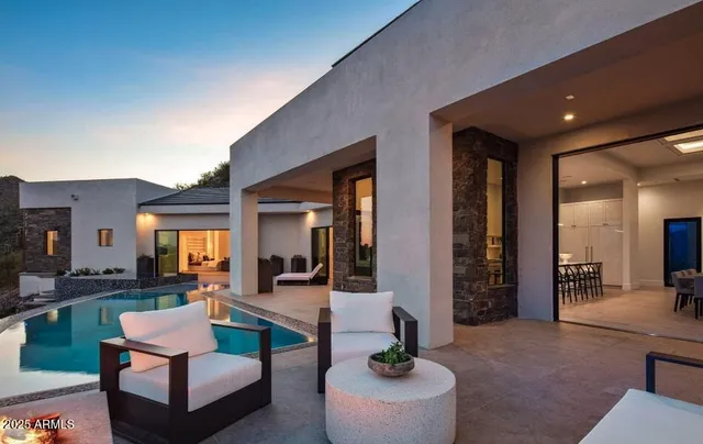 a patio with couches and a dining table with garden view