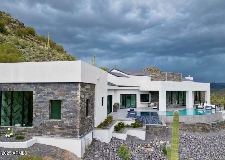 4880 East Lone Mountain Road North Cave Creek, AZ 85331 - Photo 5 of 73 a view of a house with backyard porch and outdoor seating