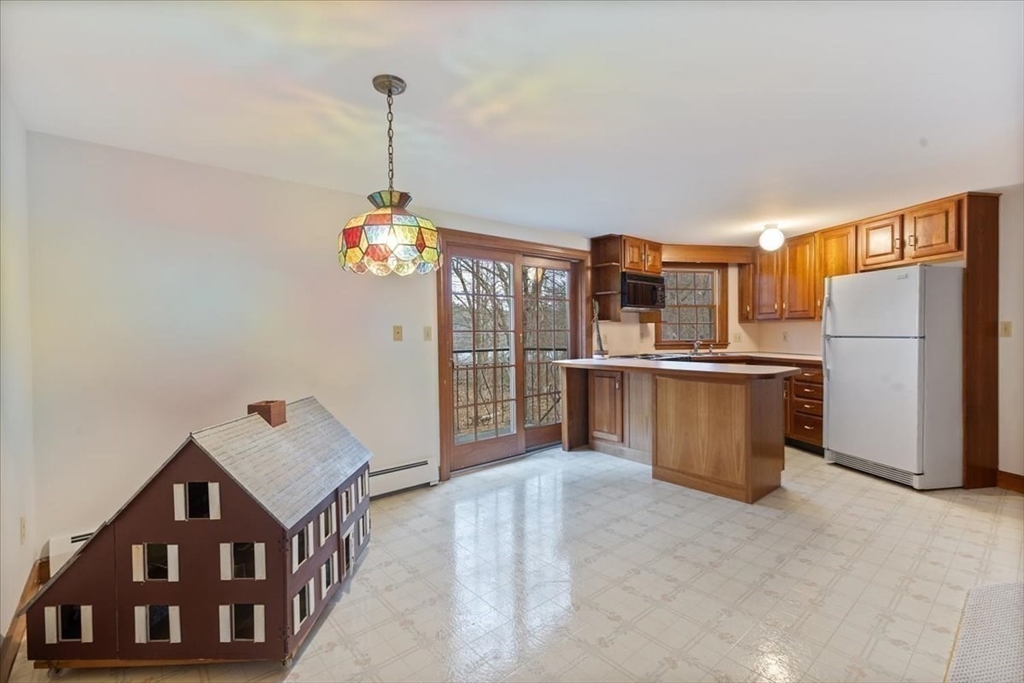 86 Dodges Row Wenham, MA 01984 - Photo 25 of 40 a living room with stainless steel appliances kitchen island granite countertop a refrigerator a stove top oven a sink and dishwasher
