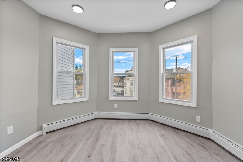 1033 East 23rd Street, Unit 2 Paterson, NJ 07513 - Photo 13 of 21 an empty room with wooden floor and windows