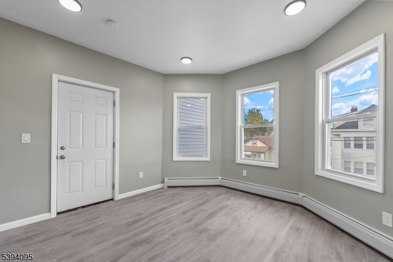 1033 East 23rd Street, Unit 2 Paterson, NJ 07513 - Photo 14 of 21 a view of an empty room with a window and wooden floor