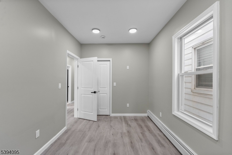 1033 East 23rd Street, Unit 2 Paterson, NJ 07513 - Photo 15 of 21 a view of a livingroom with wooden floor and window