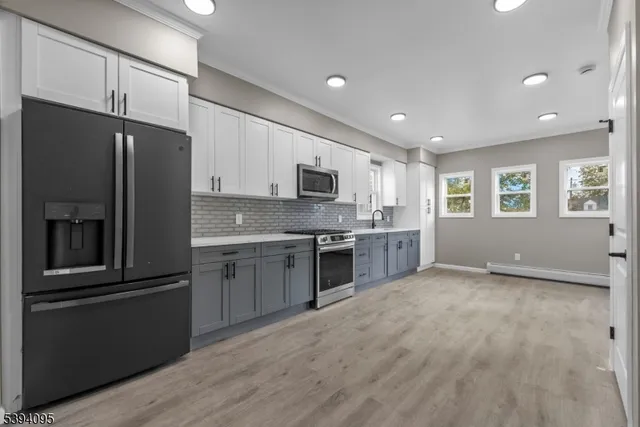 a kitchen with stainless steel appliances granite countertop a refrigerator a stove top oven a sink and dishwasher