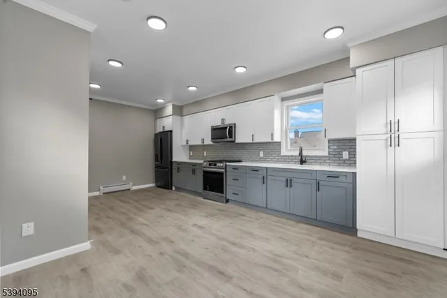 a large kitchen with a refrigerator a stove top oven a sink and dishwasher