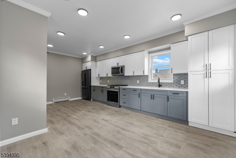 1033 East 23rd Street, Unit 2 Paterson, NJ 07513 - Photo 5 of 21 a large kitchen with a refrigerator a stove top oven a sink and dishwasher