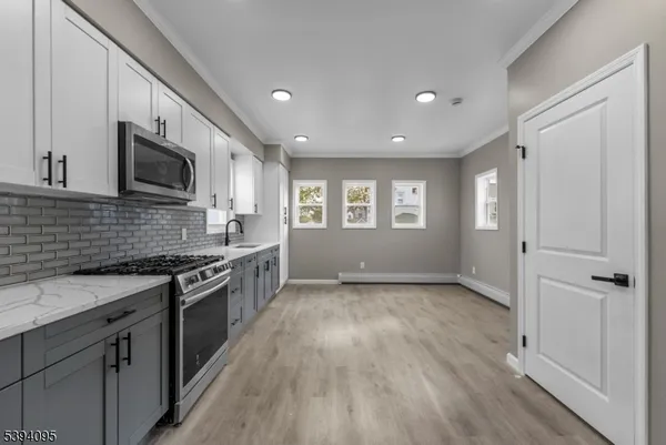 a large kitchen with stainless steel appliances granite countertop a stove and a sink