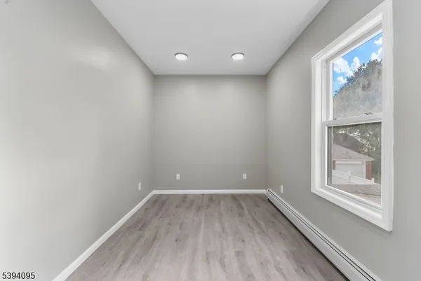 a view of a room with wooden floor and windows