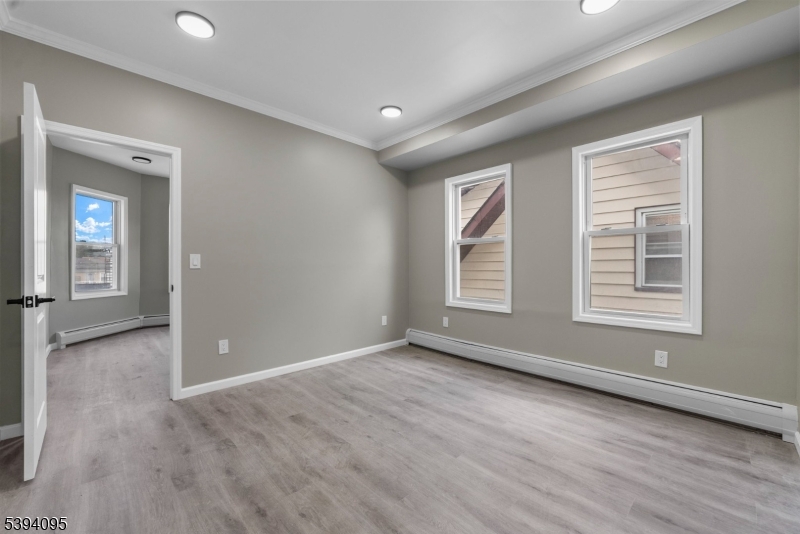 1033 East 23rd Street, Unit 2 Paterson, NJ 07513 - Photo 10 of 21 an empty room with wooden floor and windows