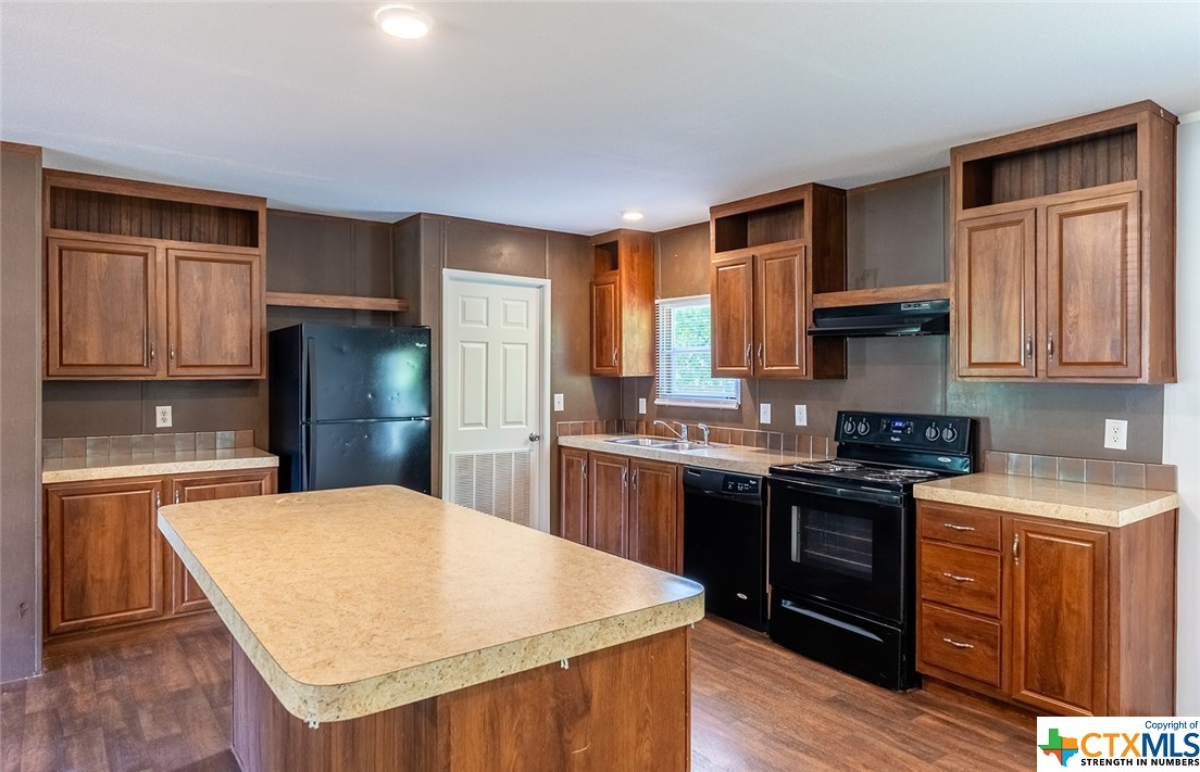 a kitchen with stainless steel appliances granite countertop a kitchen island hardwood floor sink stove and granite counter top