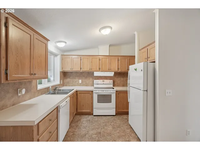 a kitchen with a sink a refrigerator and cabinets