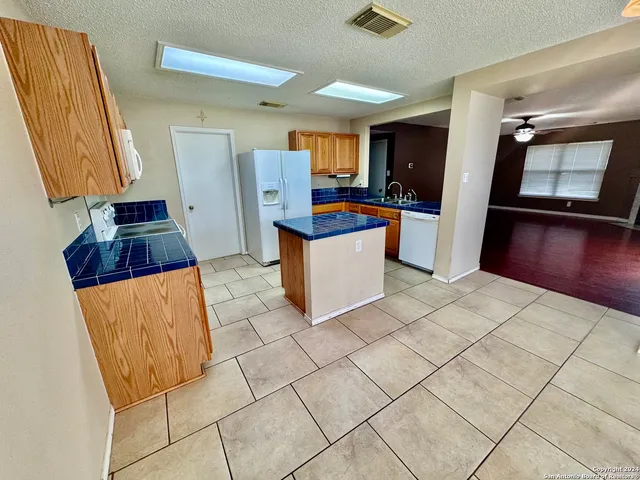 a kitchen with stainless steel appliances a stove a microwave a sink a refrigerator and cabinets