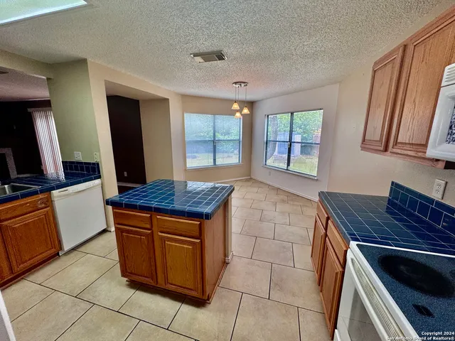 a kitchen with granite countertop a stove a sink and a microwave