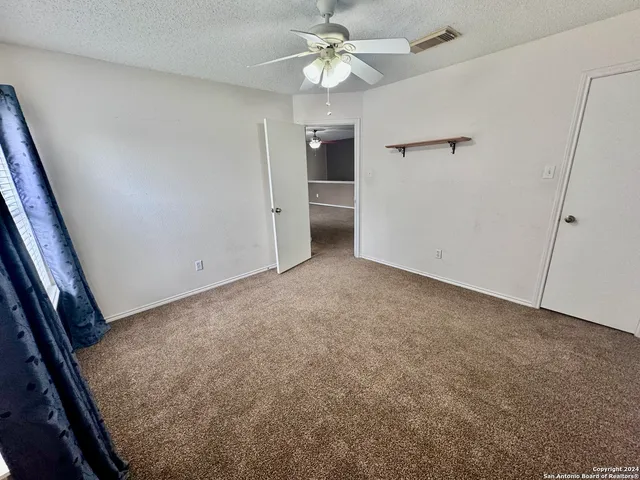 an empty room with a ceiling fan and a ceiling fan