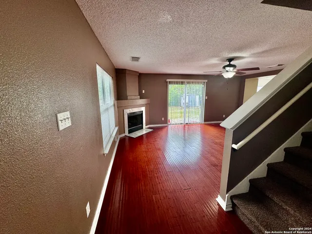 a view of main area fire place wooden floor and staircase