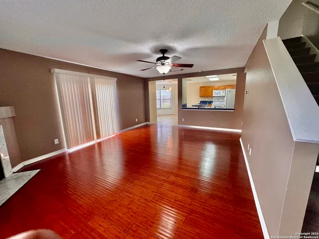 a view of an empty room with window and wooden floor