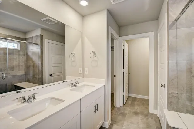 a bathroom with a double vanity sink mirror and shower