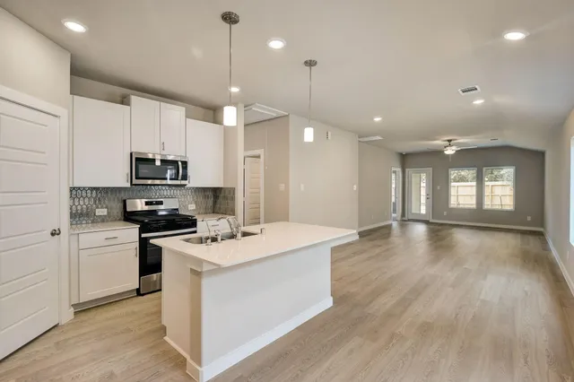 a kitchen with a stove a sink and a refrigerator