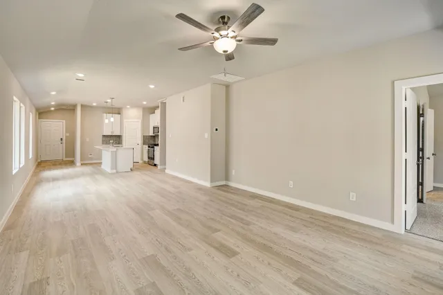a view of an empty room with a kitchen