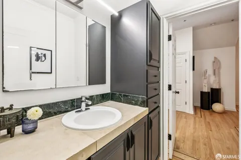 a bathroom with a granite countertop sink toilet and mirror
