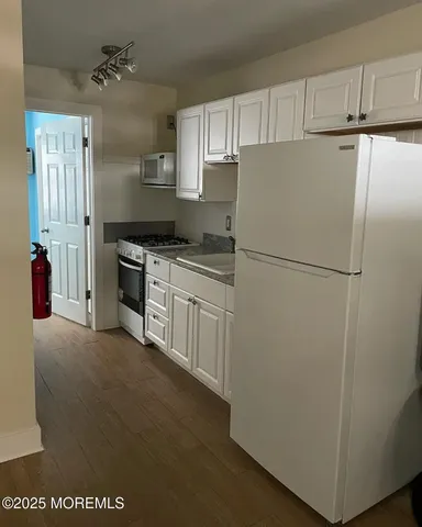 a kitchen with cabinets and a refrigerator