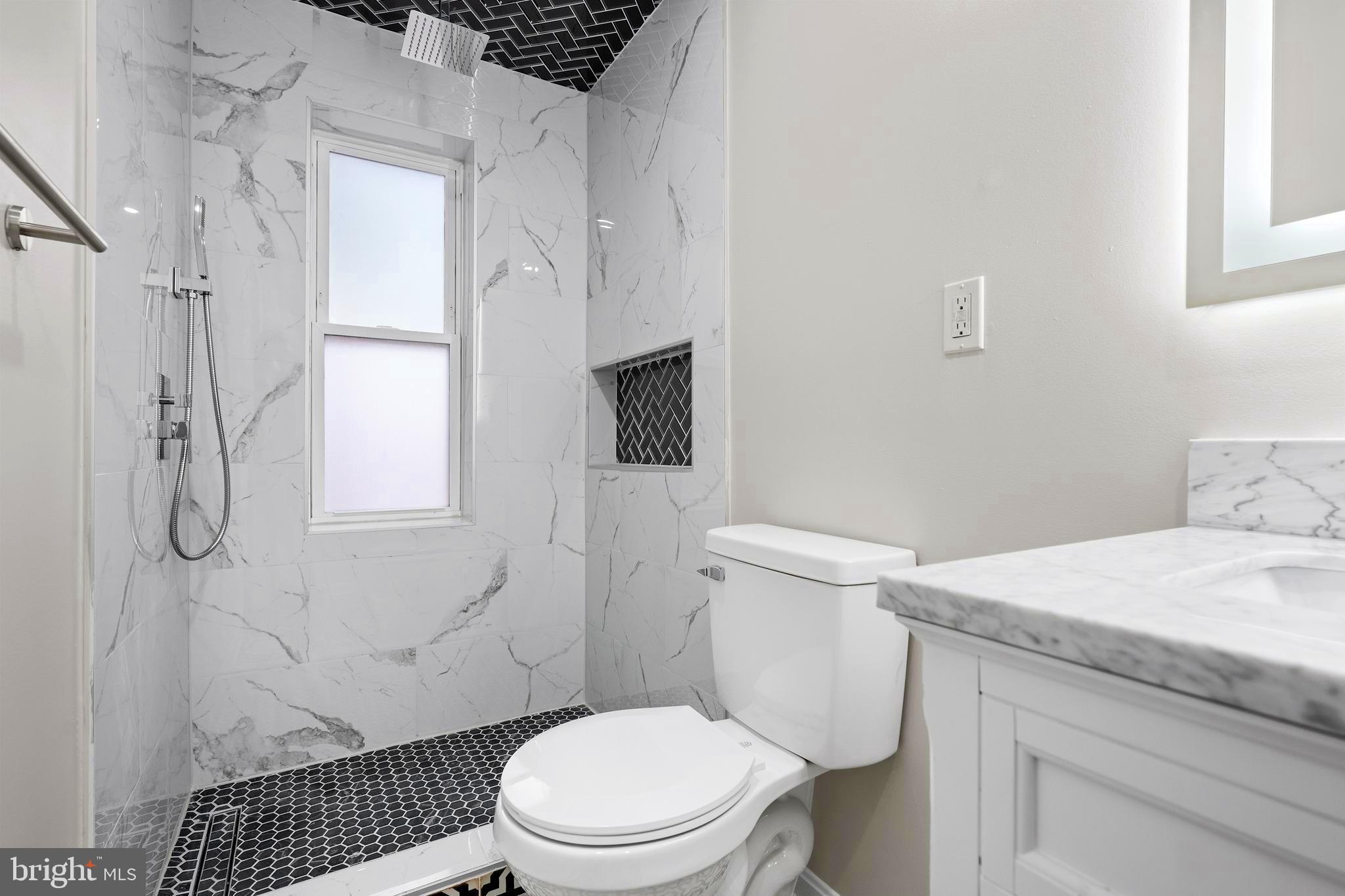 1358 Towson Street Baltimore, MD 21230 - Photo 22 of 51 a bathroom with a granite countertop toilet sink and shower