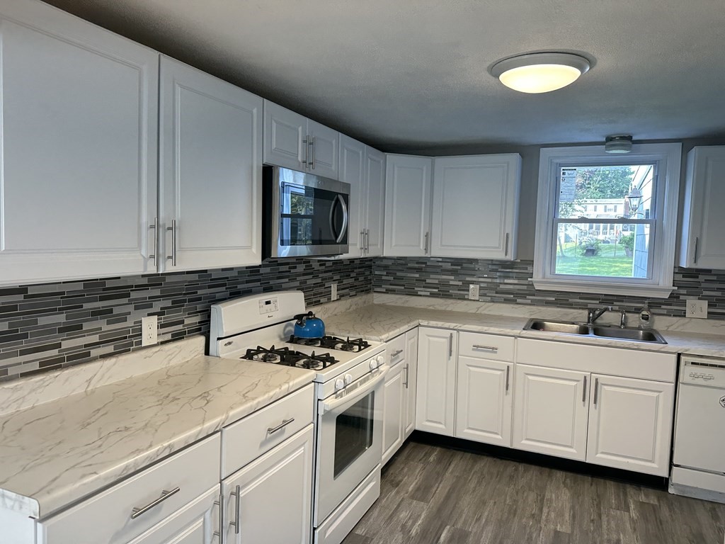 20 Eames Street North Reading, MA 01864 - Photo 5 of 13 a kitchen with granite countertop white cabinets and white appliances