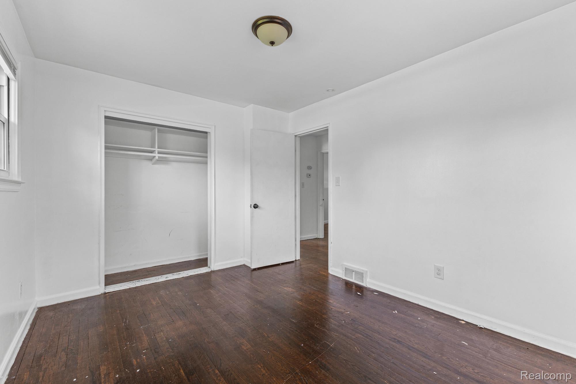 20261 Burt Road Detroit, MI 48219 - Photo 9 of 23 Interior space featuring dark wood-finish flooring, white walls, and a ceiling-mounted light fixture