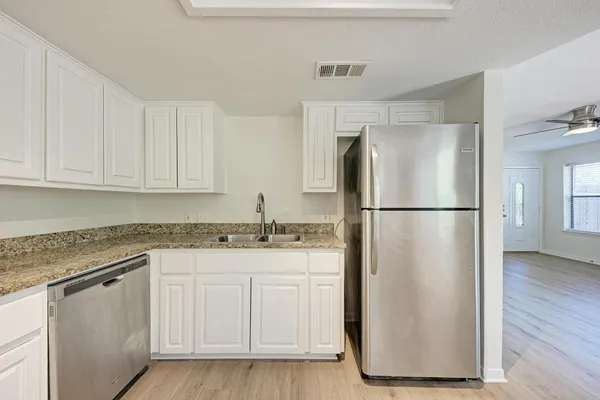 a kitchen with a refrigerator sink and cabinets