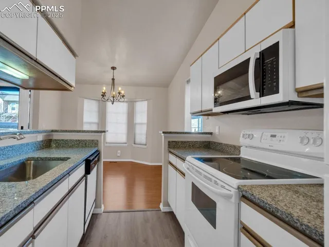 a kitchen with granite countertop a sink and steel stove