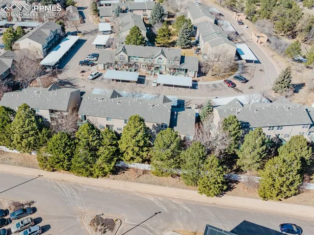 an aerial view of a houses with greenery space