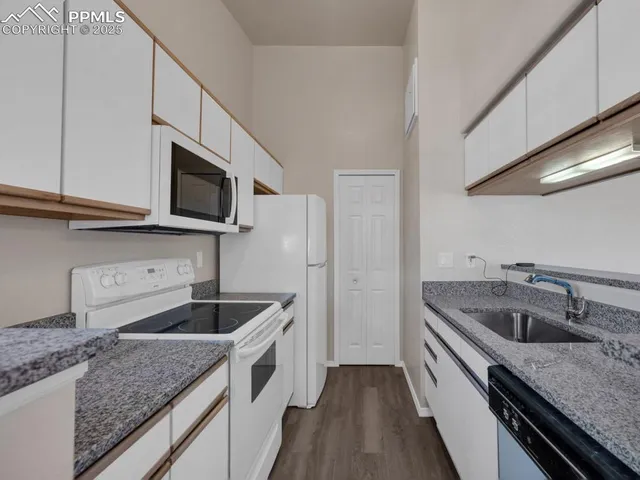 a kitchen with granite countertop a sink and steel appliances