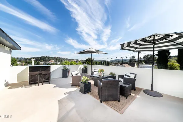 a roof deck with table and chairs