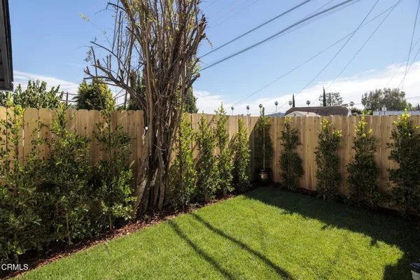 a view of a pathway of a house with wooden fence