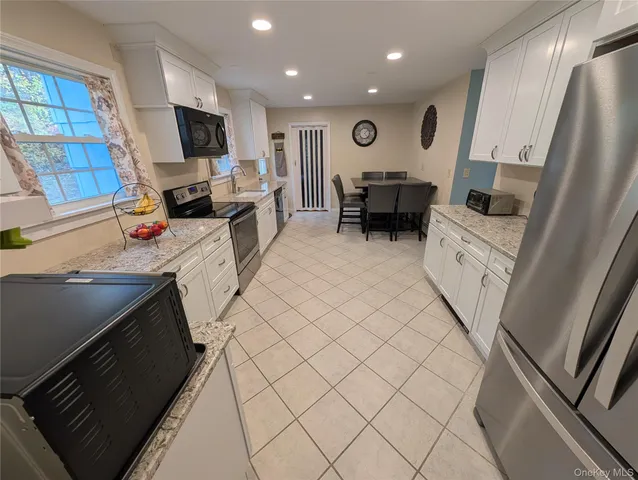 a kitchen with stainless steel appliances a refrigerator sink and microwave